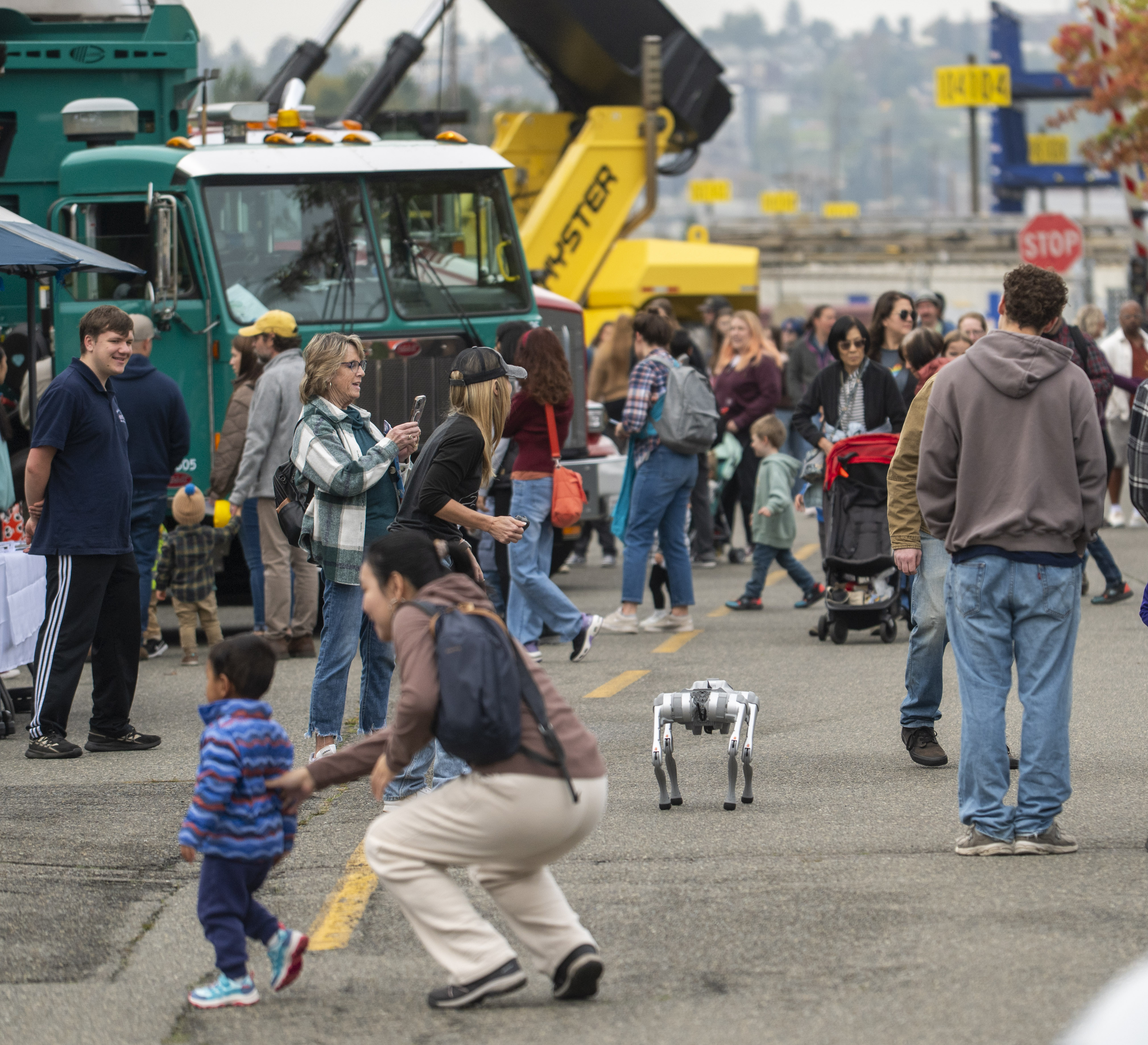 A robotic "dog" walks down a busy street of people. 